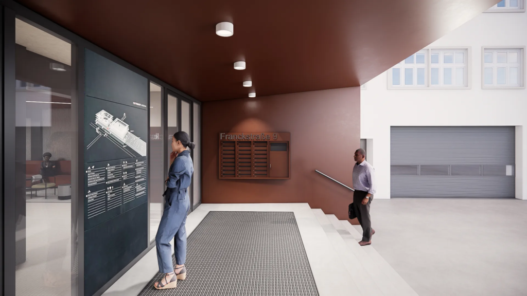 Eingangsbereich des Gebäudes an der Franckstraße 9 mit Wandplan, Briefkästen und zwei Personen, die das Foyer betreten.